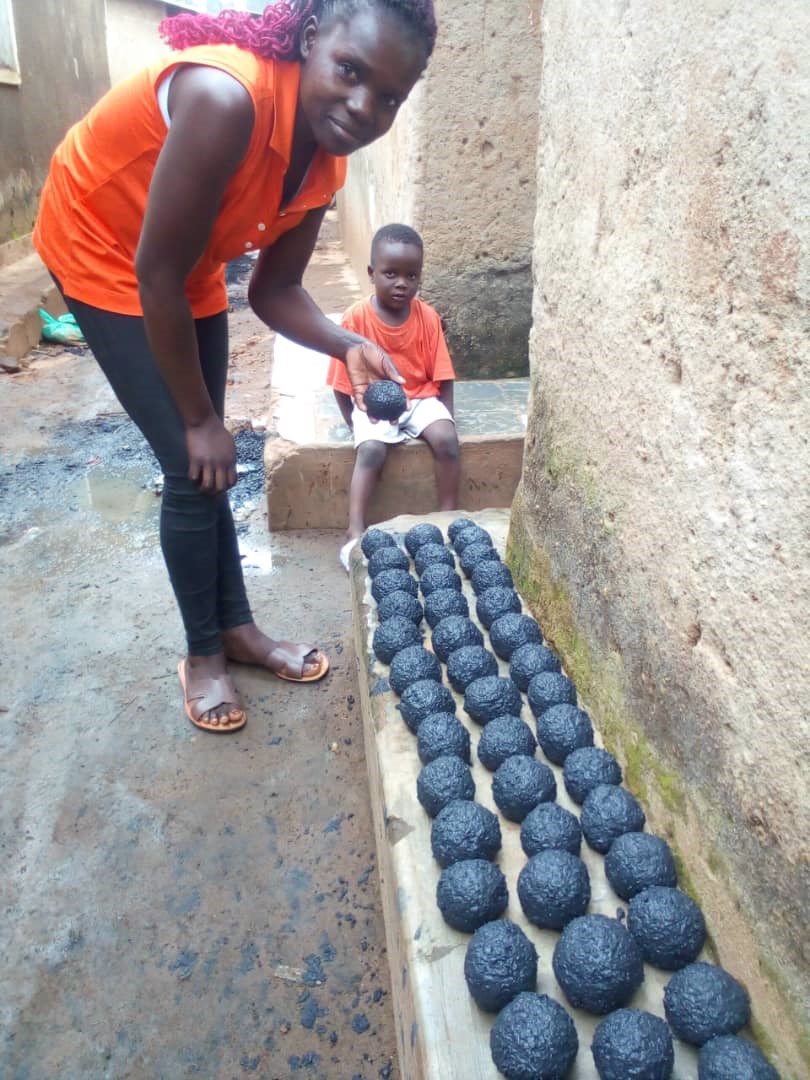 Beneficiary drying her briquettes for sale.