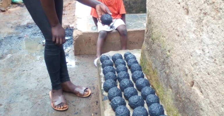 Beneficiary drying her briquettes for sale.